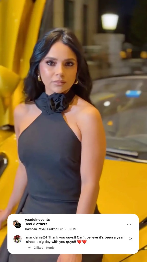 Model posing with a yellow McLaren supercar at night